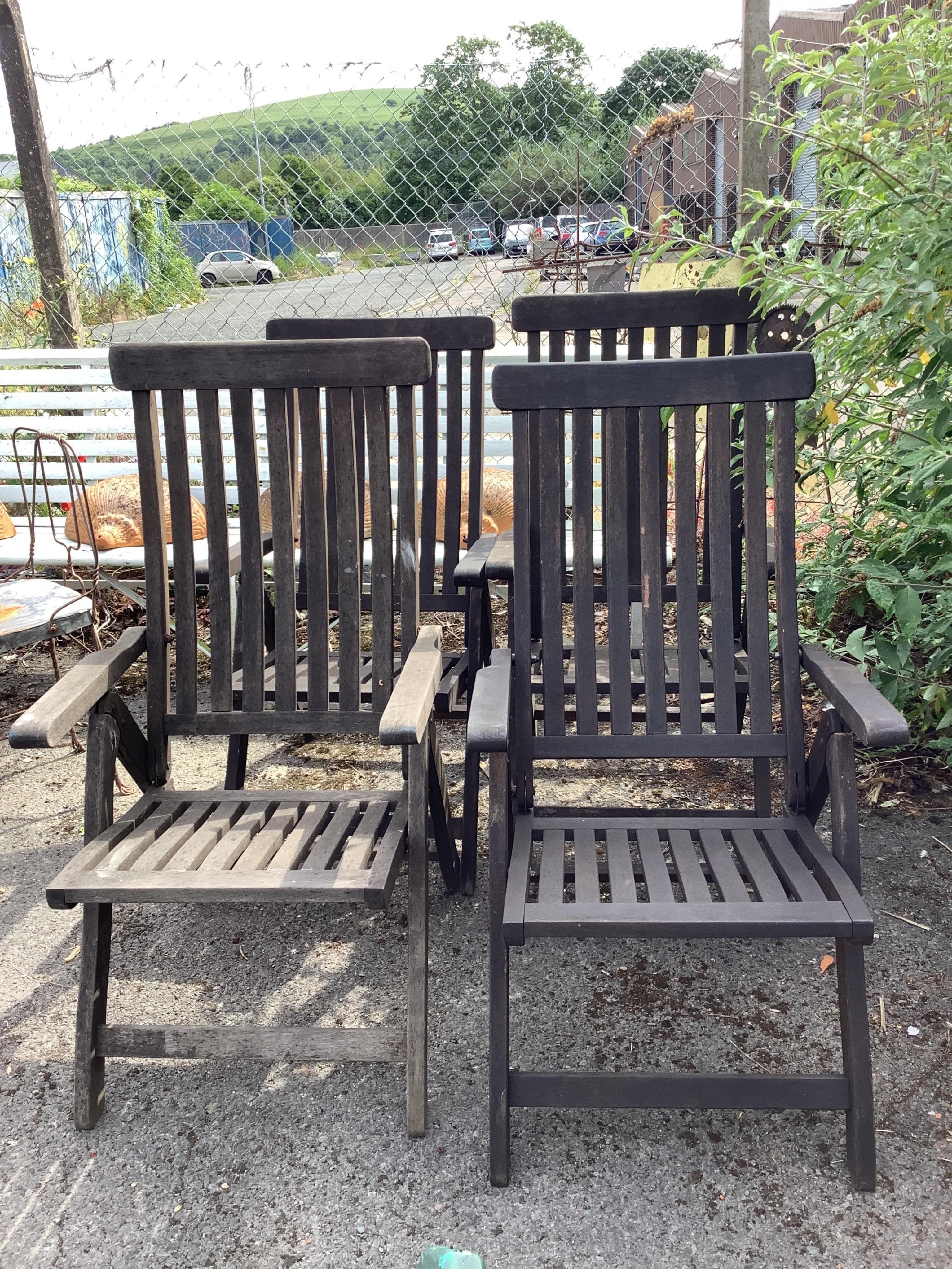 A set of four stained teak folding garden armchairs. Condition - fair